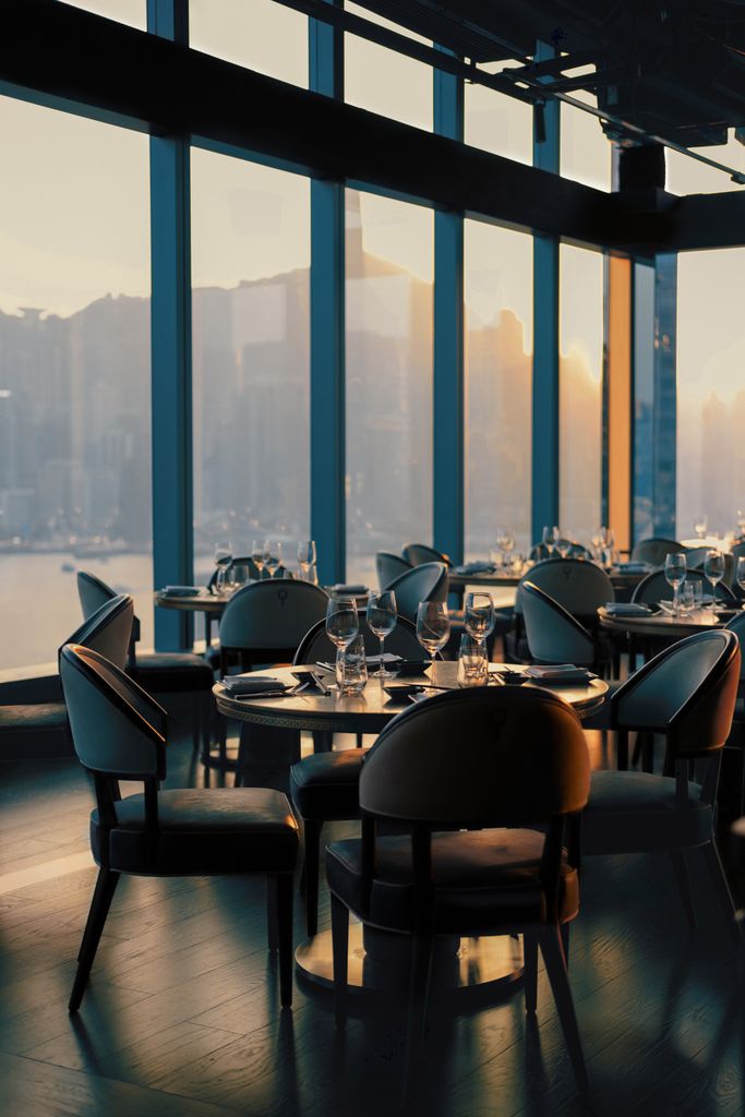 Beautiful restaurant interior with city skyline view during sunset, elegant and sophisticated.